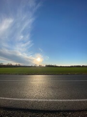 Vertical shot of an asphalt road near field on sunset