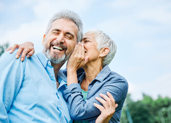 senior couple happy elderly love together retirement lifestyle smiling man woman mature ear gossip secret whispering whisper - obrazy, fototapety, plakaty