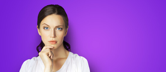 Portrait of puzzled, shocked, astonished businesswoman in white clothing, isolated over violet purple color background with copy space area. Confident business woman at studio. Wide banner composition