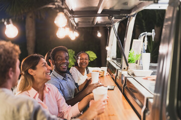 Happy multiracial people buying meal from food truck kitchen - Modern business and take away concept