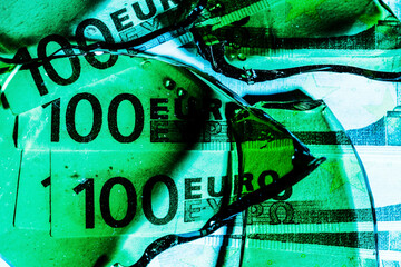one hundred euro banknotes with green broken glass. financial crisis concept