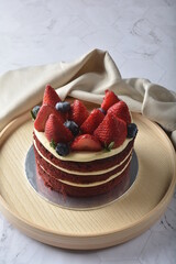 homemade fresh red velvet sponge birthday round cake with cream cheese layer and strawberry and...
