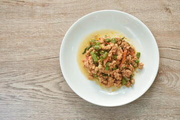 spicy stir fried chicken with slice yard long bean and basil leaf on plate