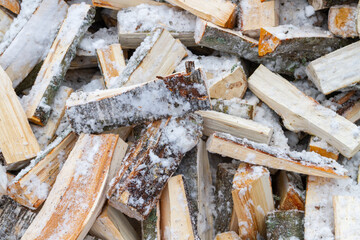 Chopped birch firewood lies in a heap on the snow in winter - 488168095