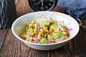eating avocado salad in a bowl on table 