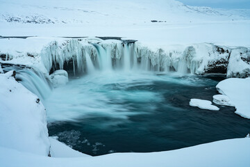 Godafoss Waterfall in Iceland, partially frozen in winter. Long exposure motion blur