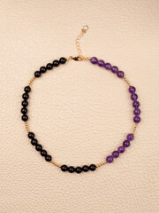 Women`s necklace of black and purple gem stones