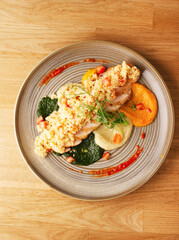 Chicken meat dish with multicolored vegetable puree and couscous. The concept of dietary nutrition. Delicious hot diet lunch dinner at the restaurant. Top view on wood background. Copy space. Healthy