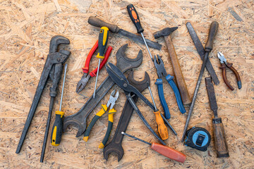 workshop tools, screwdrivers, wrenches, hammer, pliers, adjustable wrench, chisel. top view.