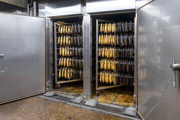 Industrial smoking of fish. Mackerel hangs on special metal rods in a smoking oven.