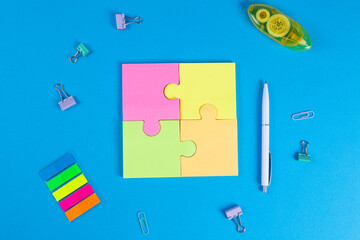 Blank sticky notes in the form of a puzzle on a blue background, space for text