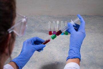 Doctora trabajando con muestra de sangre en mesada de laboratorio