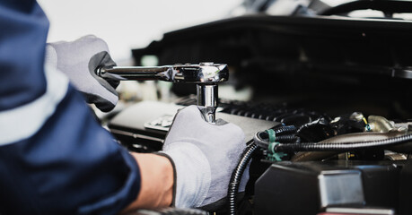 Professional mechanic working on the engine of the car in the garage. Car repair service.