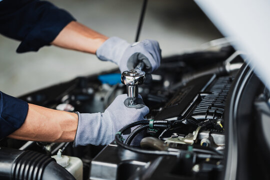 Professional mechanic working on the engine of the car in the garage. Car repair service.