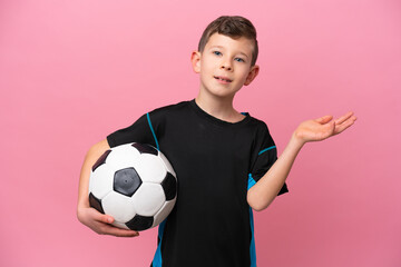 Little caucasian football player boy isolated on pink background extending hands to the side for inviting to come