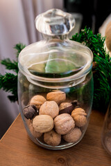 Christmas and New Year details in a photo studio. Nuts in a glass flask (2). Idea for holiday like Christmas and New year, for covers books, magazines, articles.
