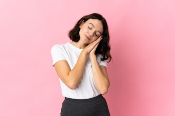 Teenager Ukrainian girl isolated on pink background making sleep gesture in dorable expression