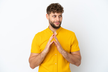 Young handsome caucasian man isolated on white background scheming something
