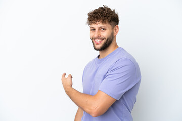 Young handsome caucasian man isolated on white background pointing back