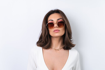 Naklejka premium Young woman in a cocktail dress, gold chain, bright spring pink makeup on a white background. In fashionable stylish sunglasses.
