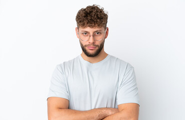 Obraz premium Young handsome caucasian man isolated on white background With glasses and arms crossed