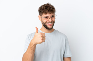 Young handsome caucasian man isolated on white background With glasses and with thumb up