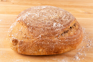 Round healthy bread made of whole wheat flour on sourdough close-up on a wooden background. Proper nutrition. Healthy lifestyle.