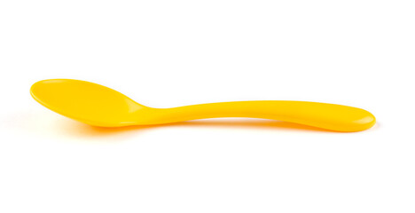 Bright yellow plastic spoon for feeding the baby on a white isolated background. Side view.