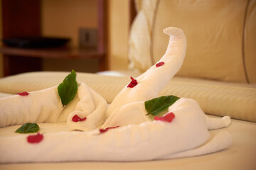 Fototapeta na wymiar A swan made of towels on a bed in a hotel.