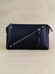 A beautiful women's bag stands on a paper background.