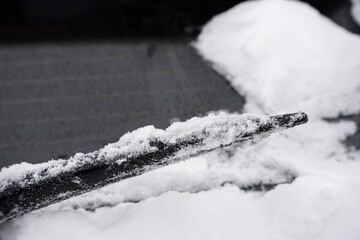 frozen wiper blade is cover in snow and ice after a snow storm