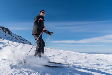 Fototapeta na wymiar Close-up of a skier sliding down the mountain on the snow at the ski resort