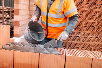 industrial details - Construction bricklayer worker building walls with bricks, mortar and putty...