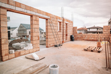 Construction site, tools, wheel barrow, sand and bricks at new house building, cement mixer machine...