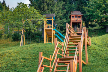 Wodden swing on the yard of Carpachian village. Picturesque summer view of mountain village, Ukraine, Europe. Traveling concept background.