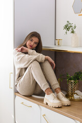 Portrait of fashionable women in beige sports suit and stylish leather oxfords shoes posing in the...