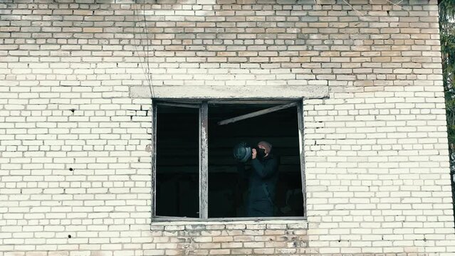 A man with an anti-tank weapon in an abandoned house. Civilian population with weapons to destroy tanks.