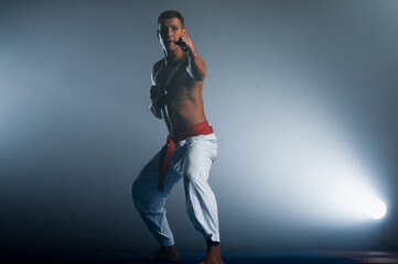 The karate guy in white kimono and black belt training karate