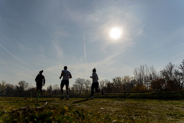Obraz na płótnie Canvas Silhouettes of three runners, running together