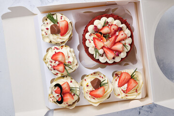 Gift set for the holiday. Red velvet bento cake with fresh strawberries and red velvet cupcakes with strawberries, chocolate and cream cheese cream.
