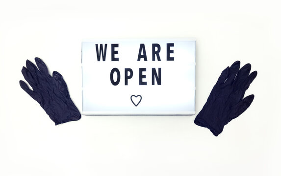 Lettering We are open next to protective gloves. Concept for establishments open during quarantine restrictions.