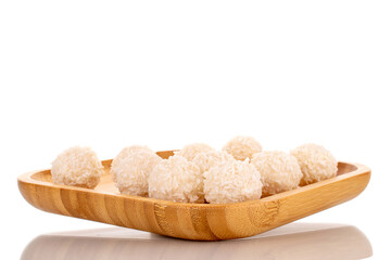 Some sweet coconut candy on a bamboo tray, macro, isolated on a white background.