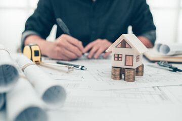 Mini model house, Money, pencil, compass  and roll blueprint plan  on blueprint house plan design....