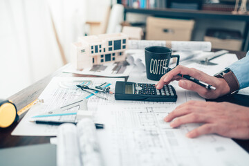 Architect engineer use calculator for calculate drawing design working on blueprint. House planning...