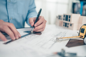 Architect engineer use pen and  angle protector drawing design working on blueprint. House planning...