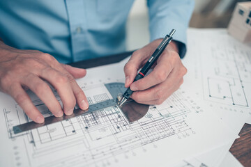 Architect engineer use pen and  angle protector drawing design working on blueprint. House planning...