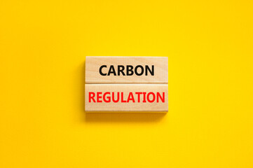 Carbon regulation symbol. Concept words Carbon regulation on wooden blocks on a beautiful yellow table yellow background. Business and carbon regulation concept, copy space.