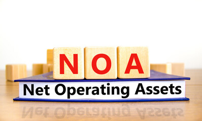 NOA net operating assets symbol. Concept words NOA net operating assets on wooden cubes on book on...