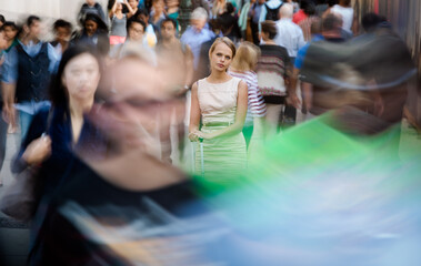 Crowd of people walking on city street - motion blurred image with unrecognizable faces - Young...