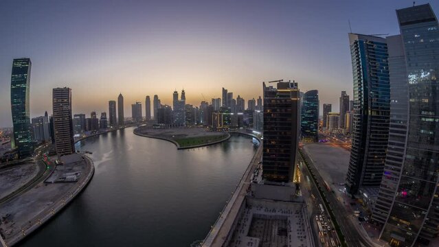 Cityscape panorama of skyscrapers in Dubai Business Bay with water canal aerial day to night timelapse